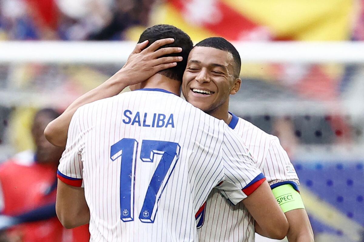 France's forward Kylian Mbappe celebrates with William Saliba after winning the match against Belgium. — AFP