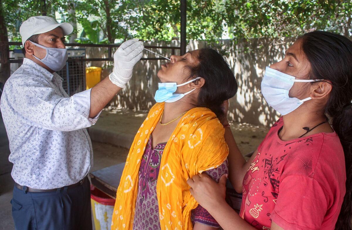 A healthcare worker collects a swab sample of a woman for Covid-19 test in Gurugram on April 17, 2023. — PTI