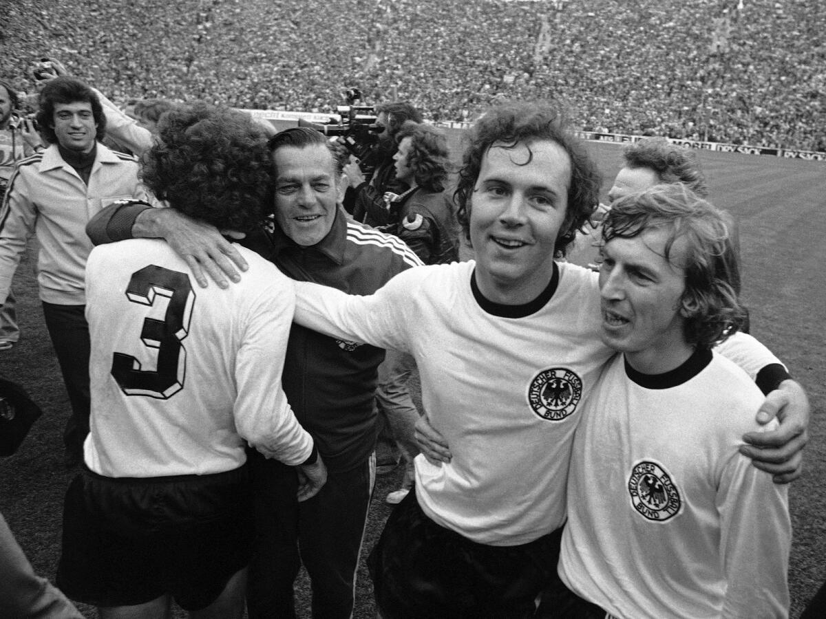 Franz Beckenbauer (second from right) embraces his teammate Juergen Grabowski after West Germany beat the Netherlands 2-1 in the 1974 World Cup final. — AP file
