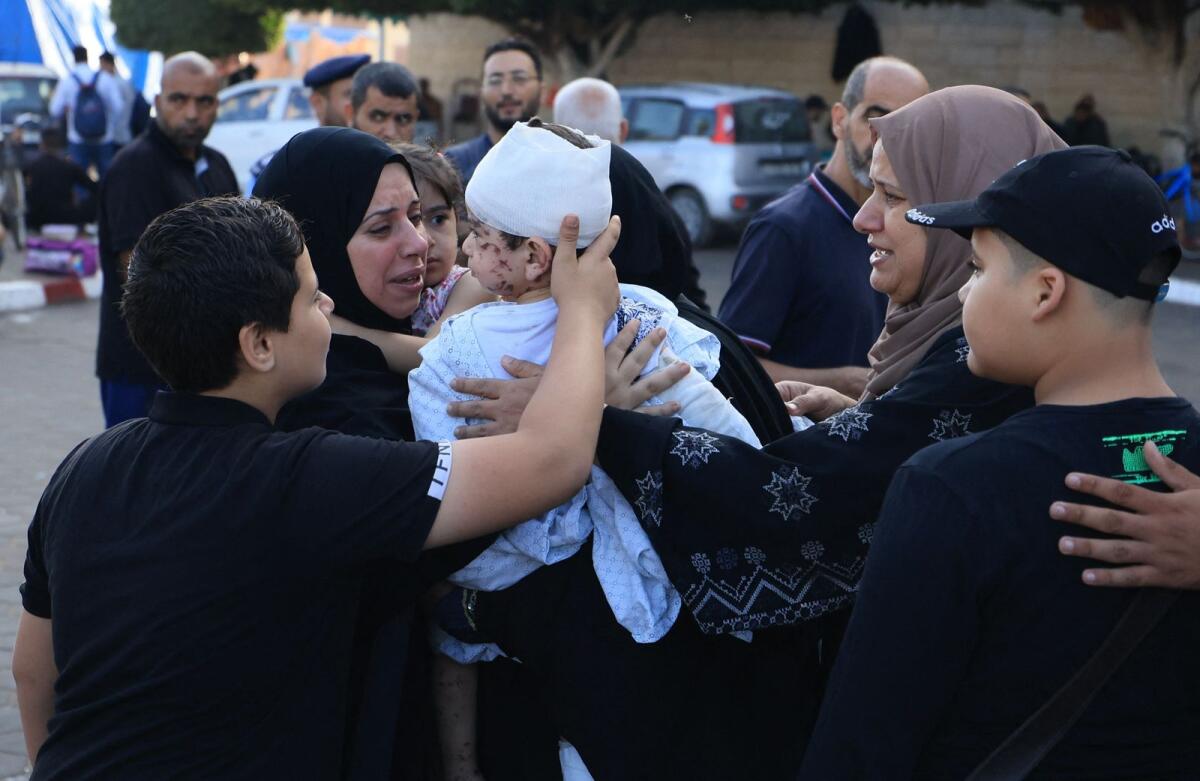 A woman holds an injured toddler following the Israeli bombardment of Deir Balah in the central Gaza Strip, outside the Shuhada Al-Aqsa hospital. Photo: AFP