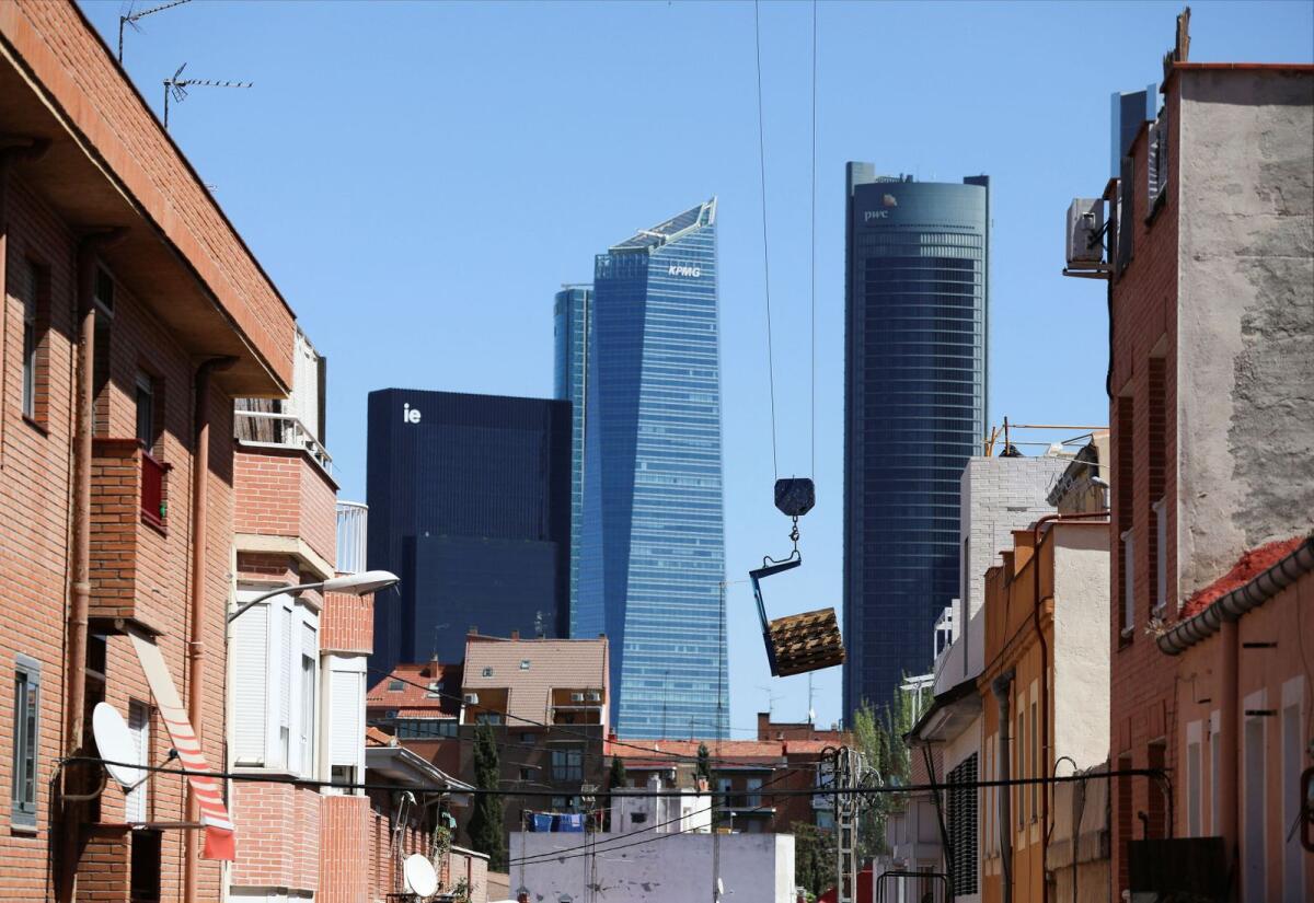 A crane is seen among old block of flats in the district of Tetuan with the Four Towers business district in the background, as Spanish government is due to pass a property reform to allow 50,000 homes in its social housing scheme in Madrid, Spain,  on Monday.— Reuters