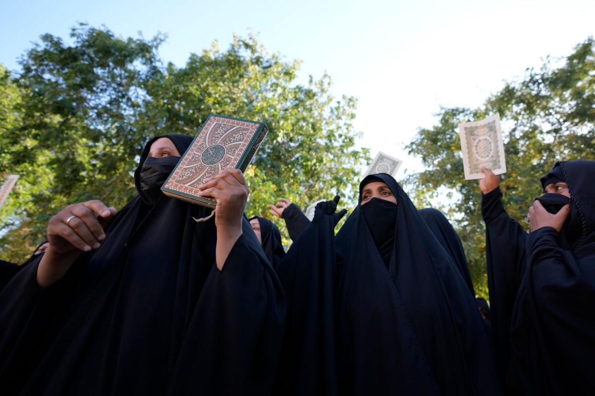 Iraqis raise copies of the Holy Quran during a protest in Baghdad, Iraq, on Saturday. — AP