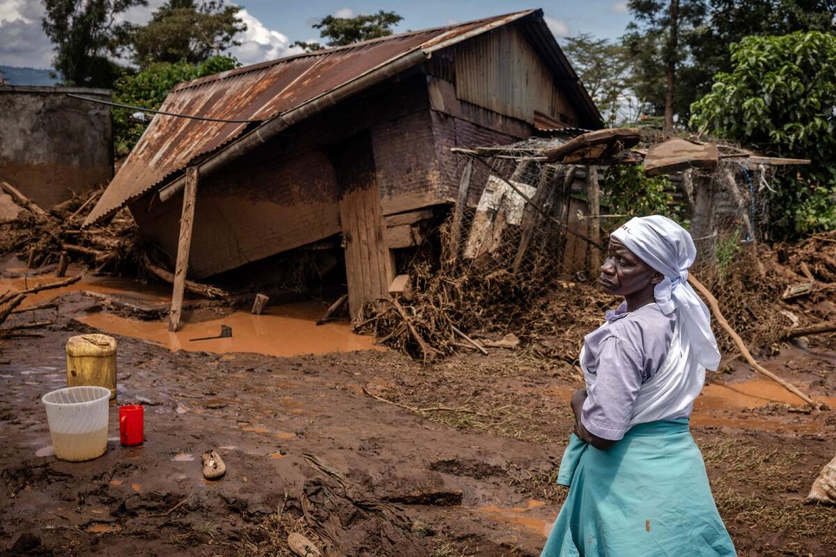 A woman stands assessing the damage in front of her destroyed house in an area heavily affected by torrential rains and flash floods in the village of Kamuchiri, near Mai Mahiu, on Monday.  — AFP