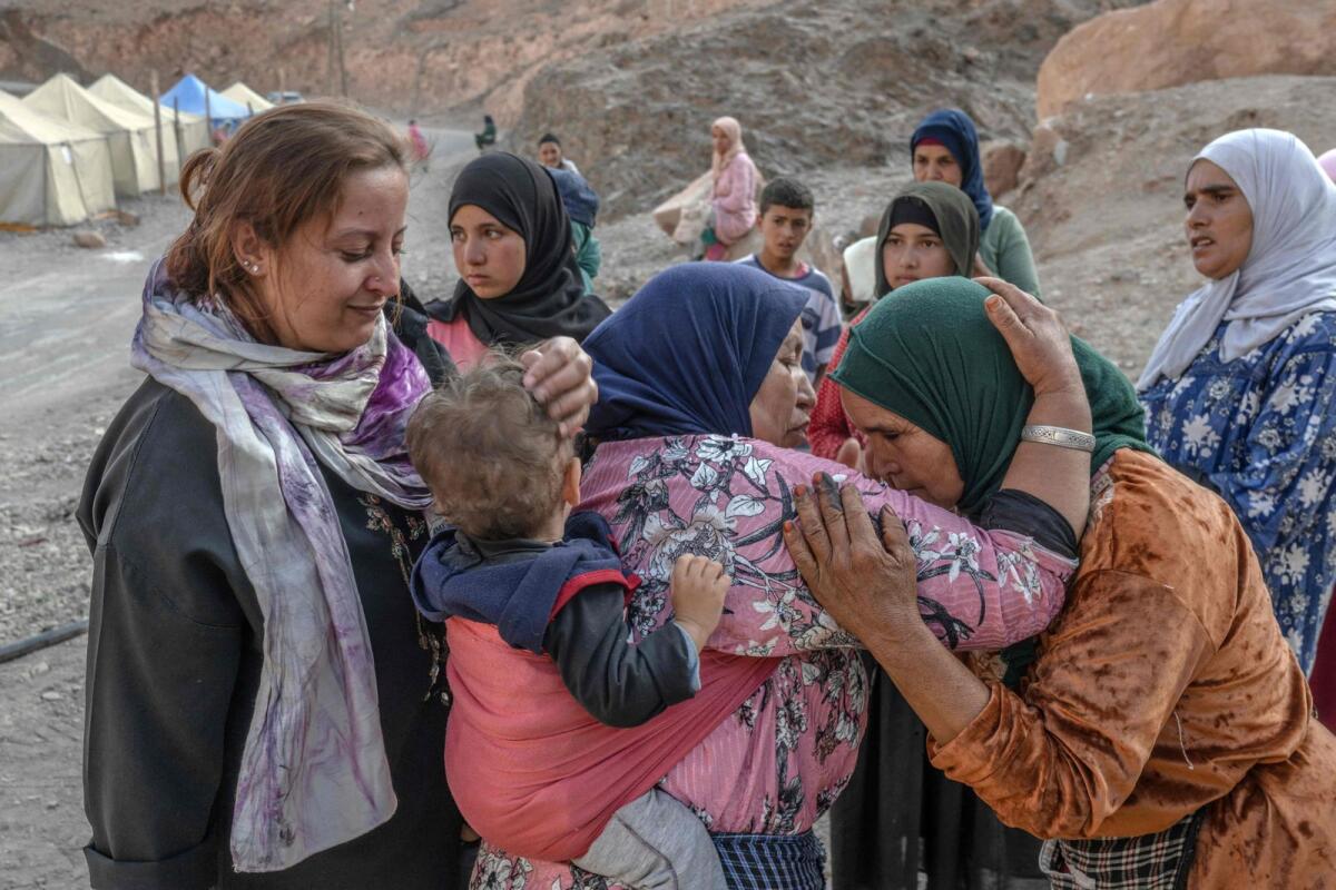 Women embrace each other upon meeting for the first time since a devastating earthquake hit their area in a village near Amizmiz in central Morocco on September 13, 2023.  — AFP