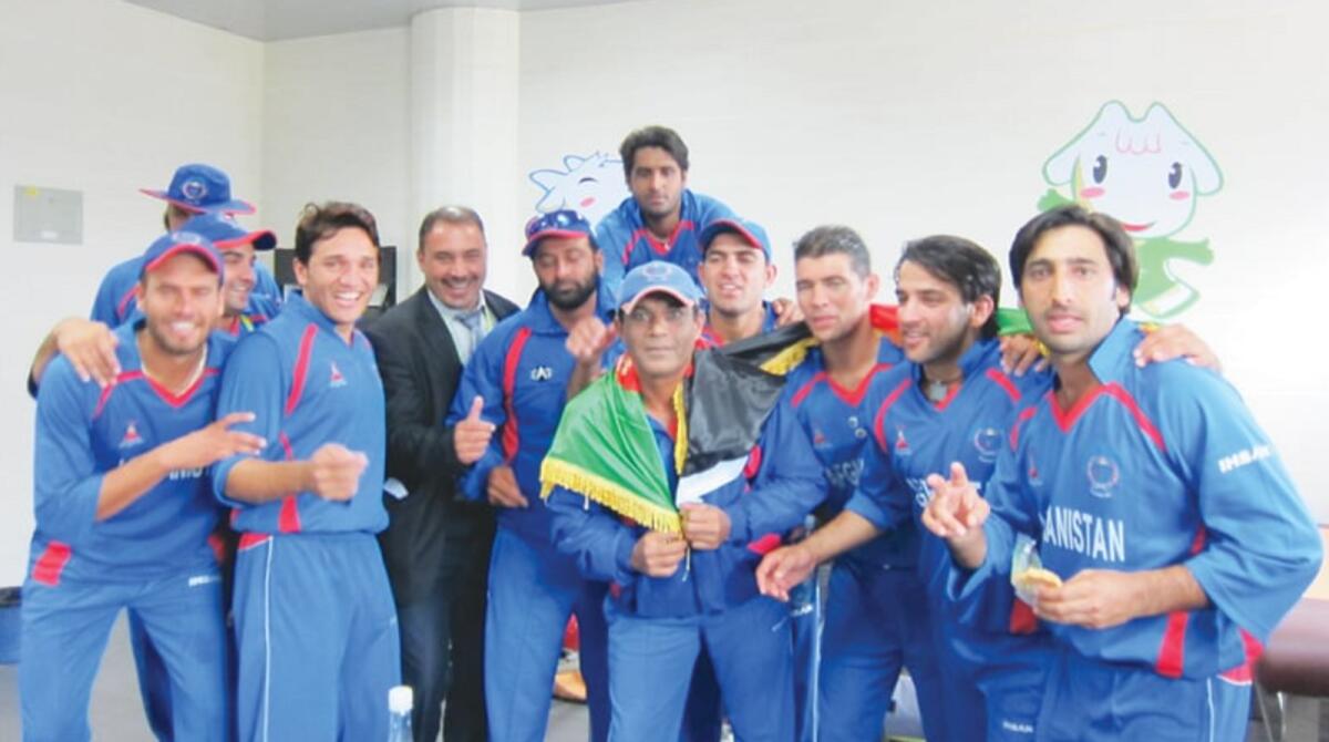 Rashid Latif (centre) with the Afghan team after winning the silver medal at the 2010 Asian Games. — Supplied photo