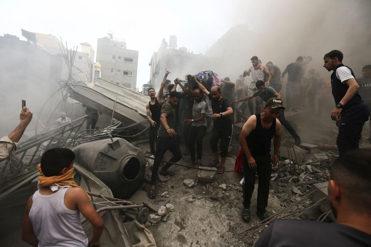 Palestinians remove a body from the rubble of a building after an Israeli airstrike Jebaliya refugee camp, Gaza Strip, Monday, Oct. 9, 2023. Photo: AP