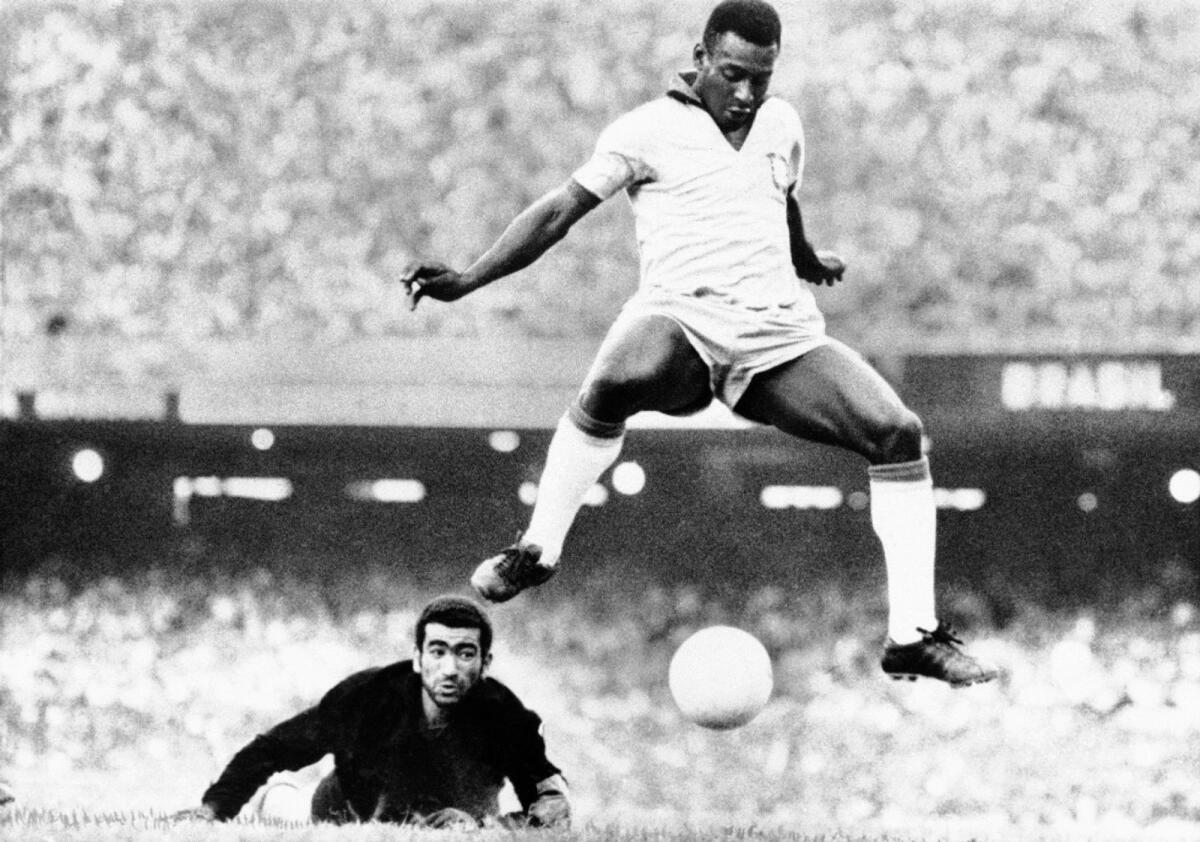 Brazil's Pele beats Venezuela's goalkeeper Fabrizio Fasano in a 1969 match in Rio de Janeiro, Brazil. - AP file
