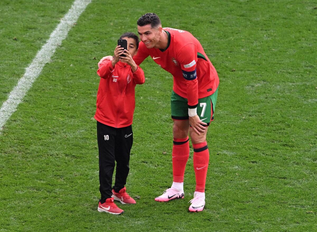 Young pitch invader takes a selfie with Cristiano Ronaldo during the match between Portugal and Turkey. — Reuters