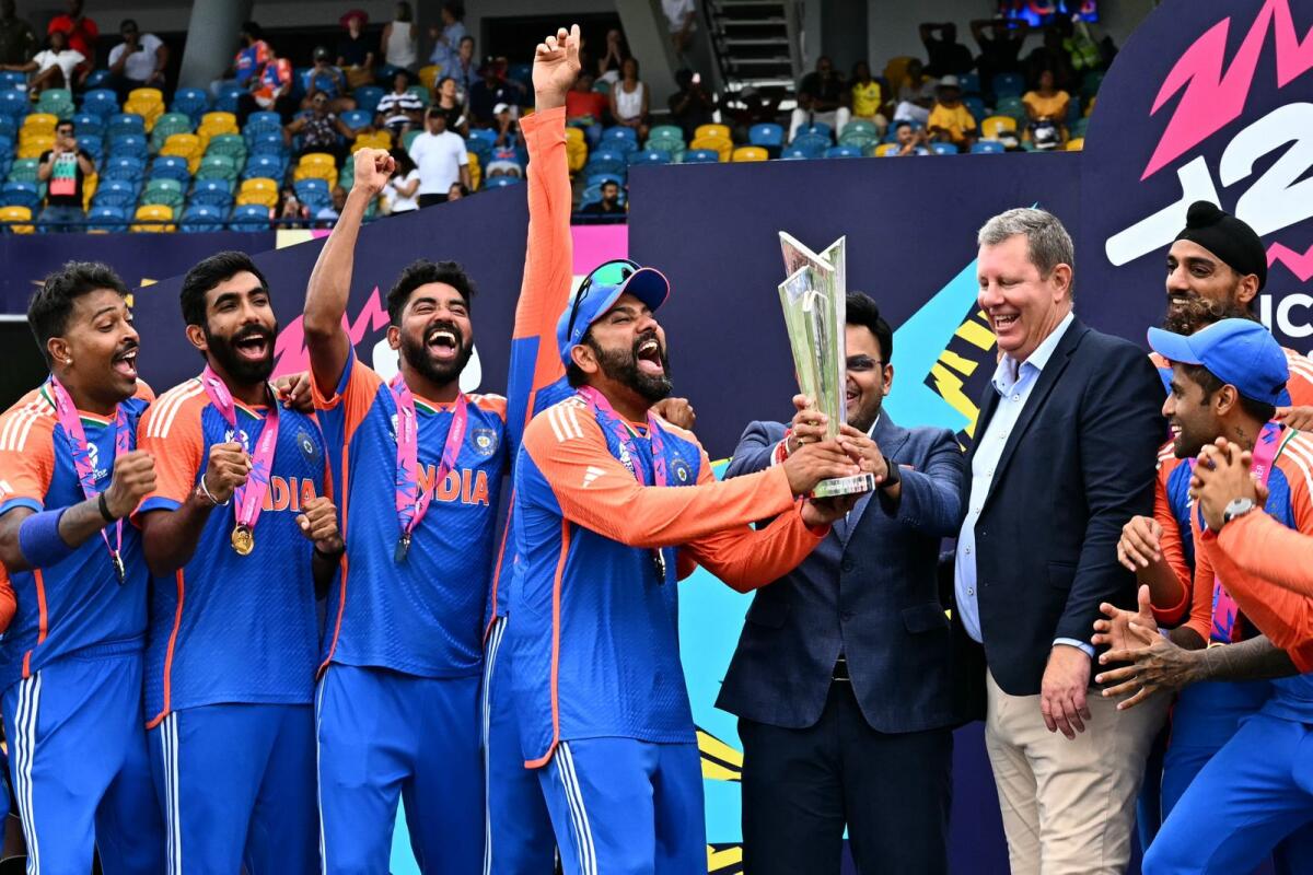 India's captain Rohit Sharma and his teammates celebrate with the trophy. — AFP