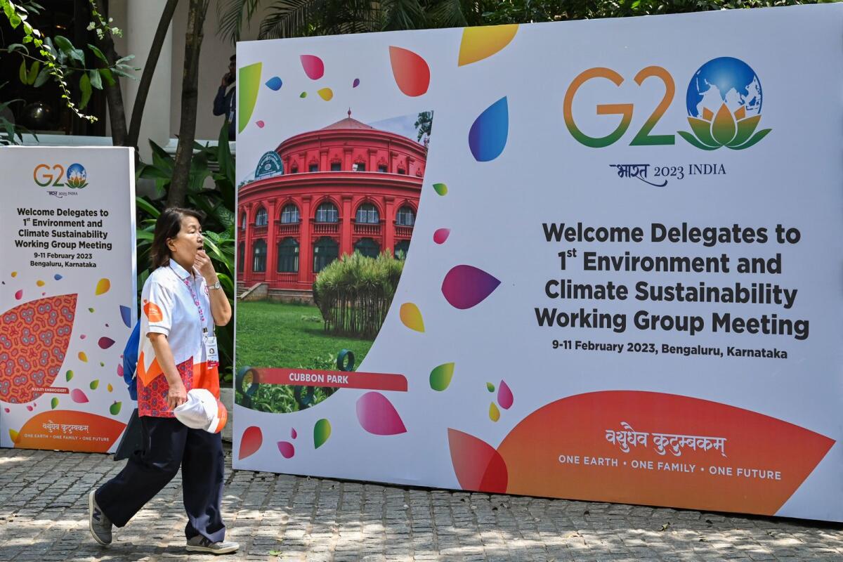 An international delegate walks past a poster of the 1st Environment and Climate Sustainability working group meeting under India’s G20 Presidency in Bengaluru on February 9, 2023. — AFP