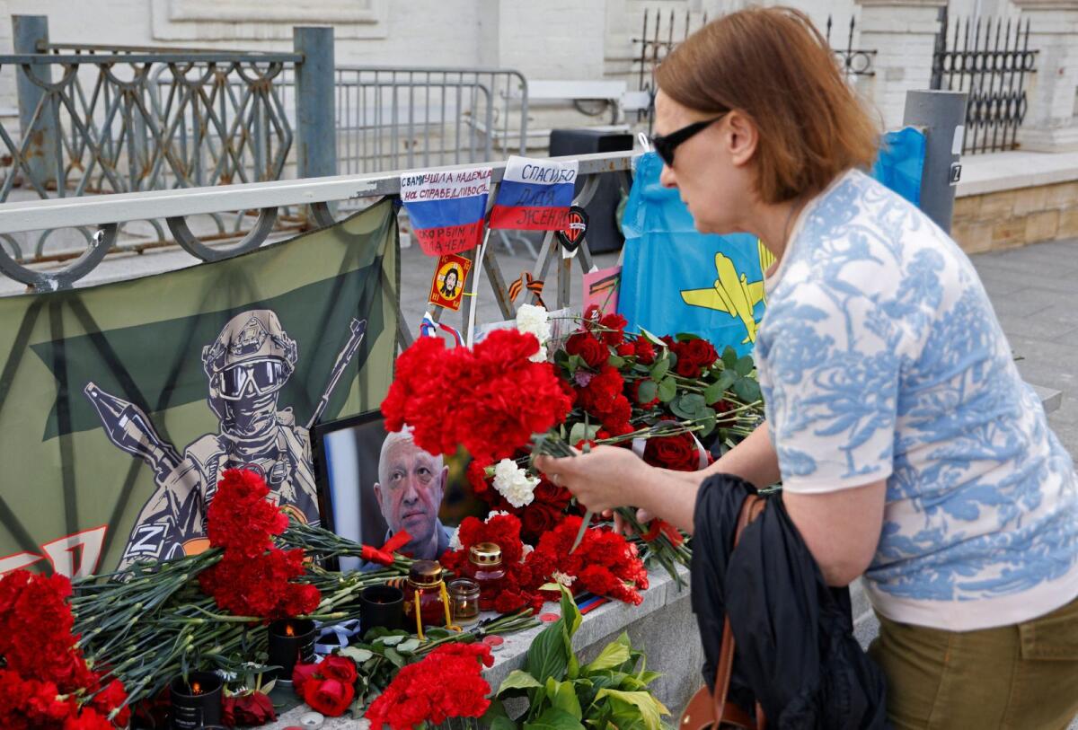 A woman lays flowers at a makeshift memorial set up after the presumed death of Yevgeny Prigozhin in Moscow, Russia on Friday. — Reuters