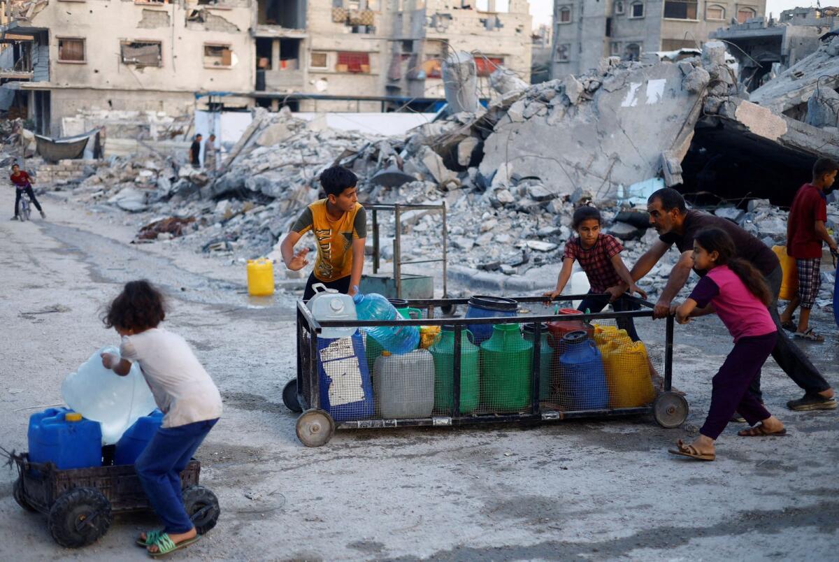 A Palestinian man and children push a cart with water containers, amid the ongoing conflict between Israel and Hamas, in southern Gaza City on June 3, 2024. — Reuters