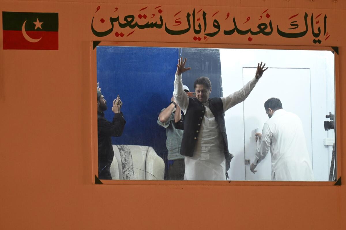 Pakistan's former prime minister Imran Khan raises hands to his supporters from behind a bulletproof shield on arrival at a rally in Lahore early on March 26, 2023. Photo: AFP