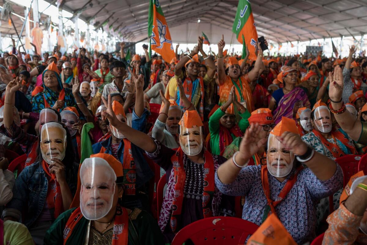 Bharatiya Janata Party upporters wear masks of Indian Prime Minister Narendra Modi during an election rally in Meerut on Sunday. — AP