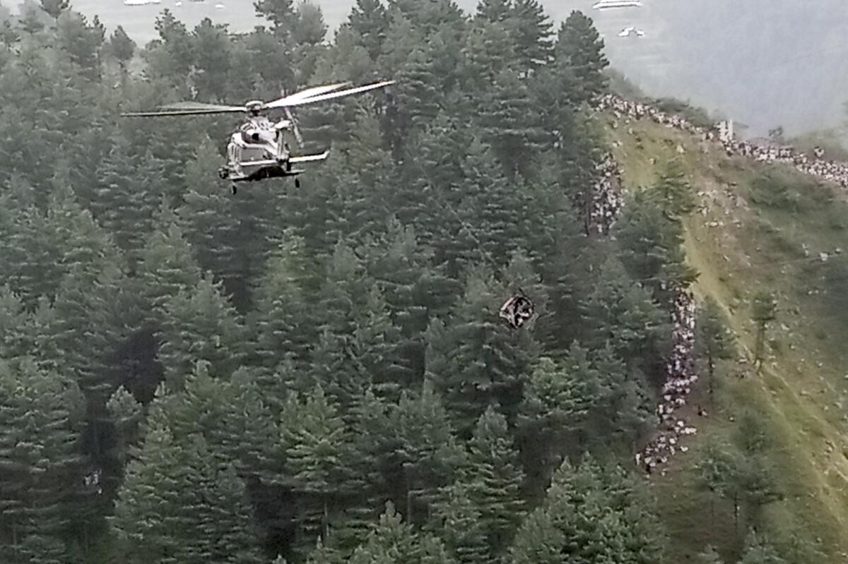 An army helicopter takes part in a rescue operation to save people trapped in the broken cable car. — AP