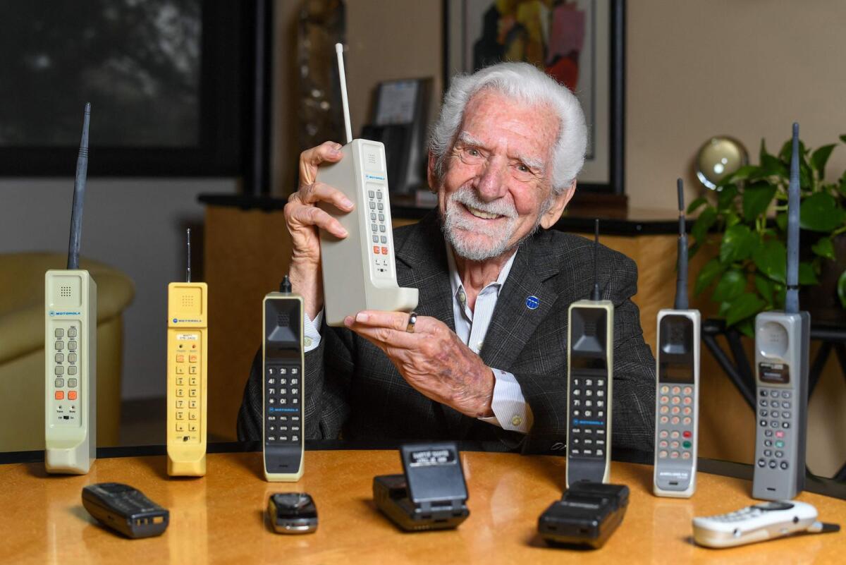 Engineer Martin Cooper holds a contemporary copy of the original cell phone he used to make the first cell phone call on April 3, 1973, in Del Mar, California, on March 20, 2023.– AFP