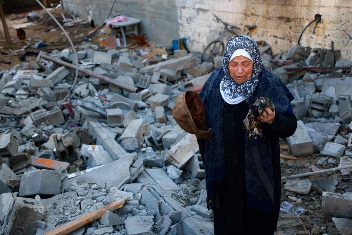A woman cries as she salvages belongings from the rubble of a destroyed house following Israeli bombardment in Rafah. Photo: AFP