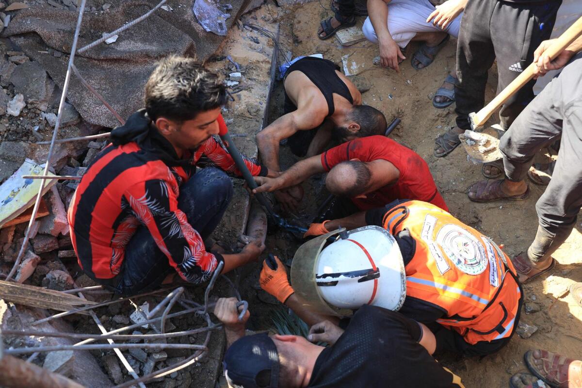 A Palestinian youth is pulled out from under the rubble of a building following an Israeli airstrike in Rafah, in the southern of Gaza Strip, on October 16, 2023. Photo: AFP