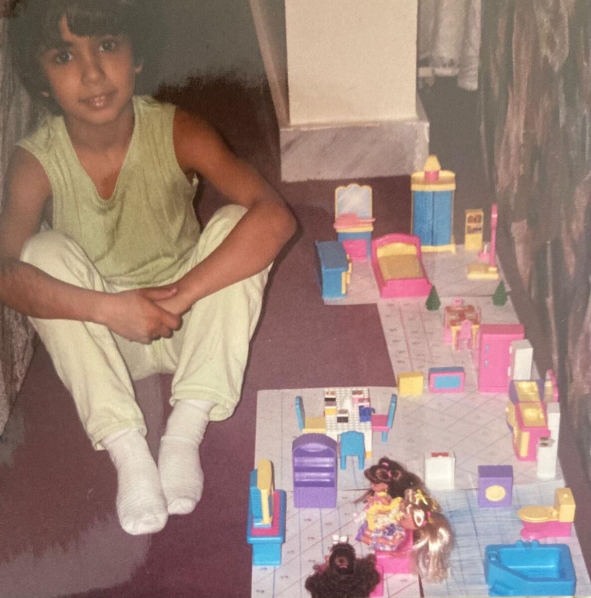 Raneem poses proudly with one of the Barbie houses she made