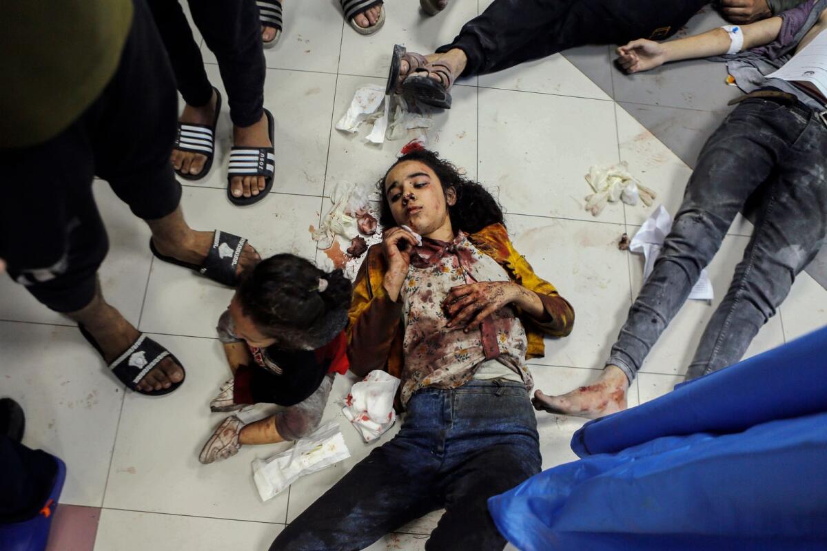 Wounded Palestinians lie on the floor in Al Shifa hospital in Gaza City fter arriving from Al Ahli hospital following an explosion there, on Tuesday,. — AP
