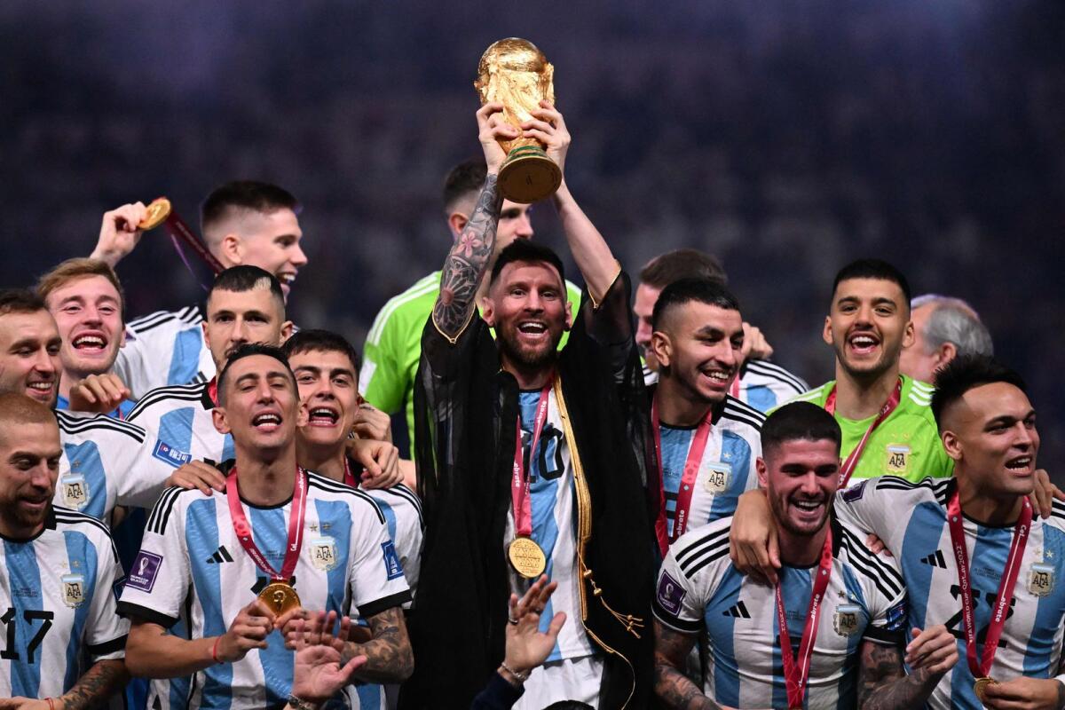 Argentina captain Lionel Messi (centre) lifts the 2022 Fifa World Cup trophy. — AFP file