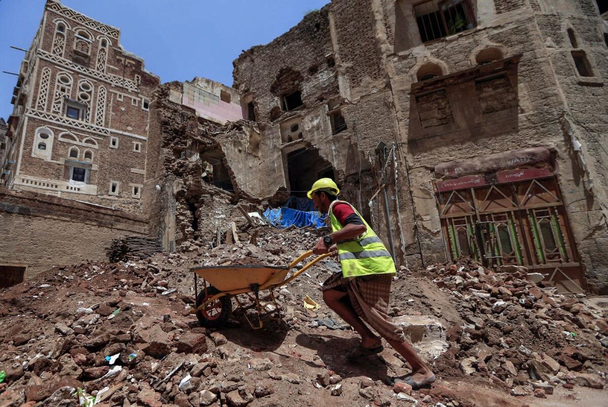 A worker removes the rubble to prepare for restoration on the site of a collapsed Unesco-listed building following heavy rains, in the old city of the Yemeni capital Sanaa, on August 12, 2020. — AFP