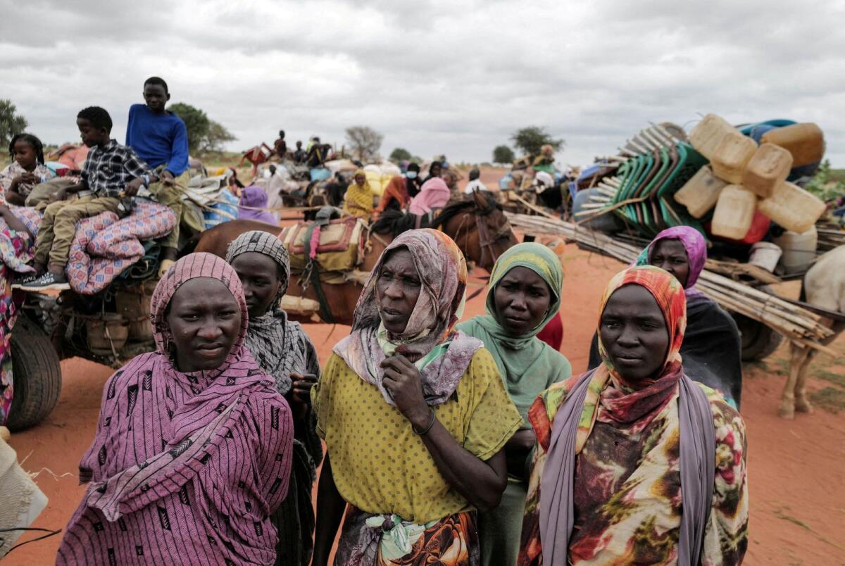 Sudanese women, who fled the conflict  in Murnei in Sudan's Darfur region, wait beside their belongings to be registered by UNHCR upon crossing the border between Sudan and Chad in Adre, Chad, on July 26, 2023. -- Reuters