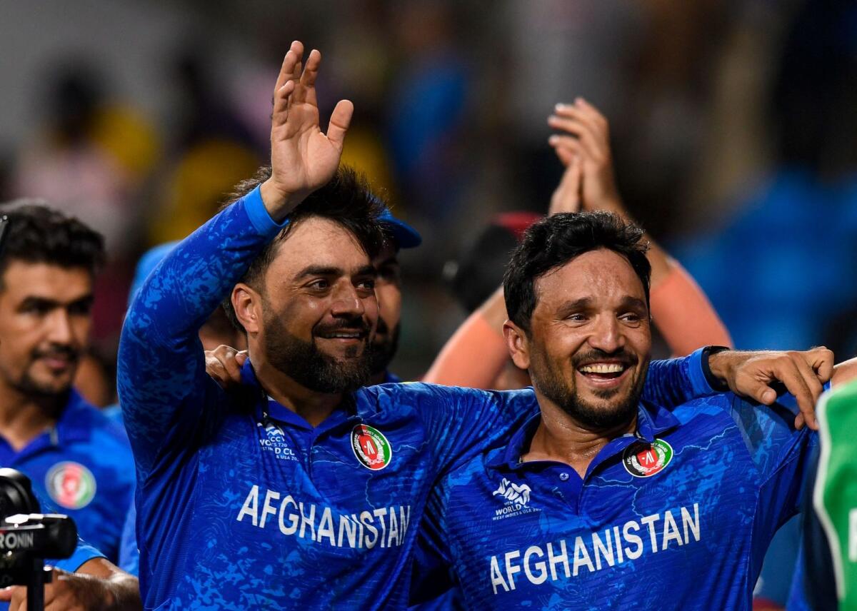 Afghanistan captain Rashid Khan (left) and Gulbadin Naib celebrate the win over Bangladesh. — AFP