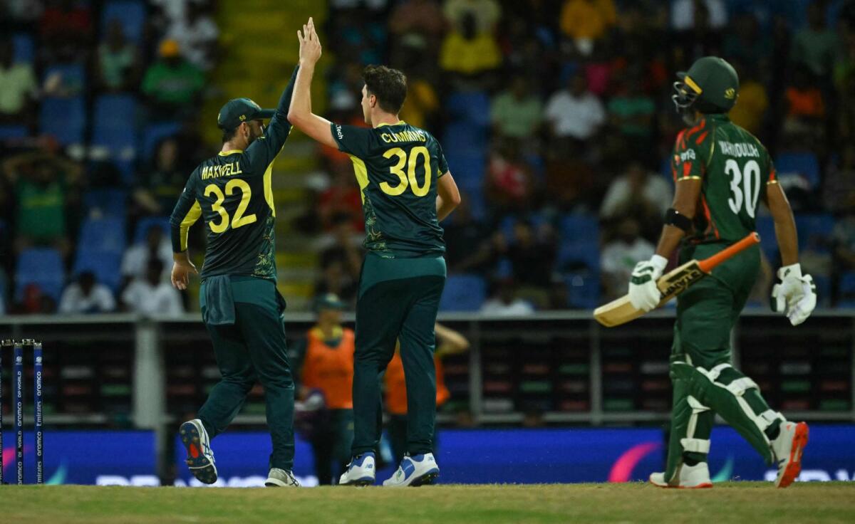 Australia's Pat Cummins (centre) celebrates a wicket with Glenn Maxwell during the match against Bangladesh. — AFP