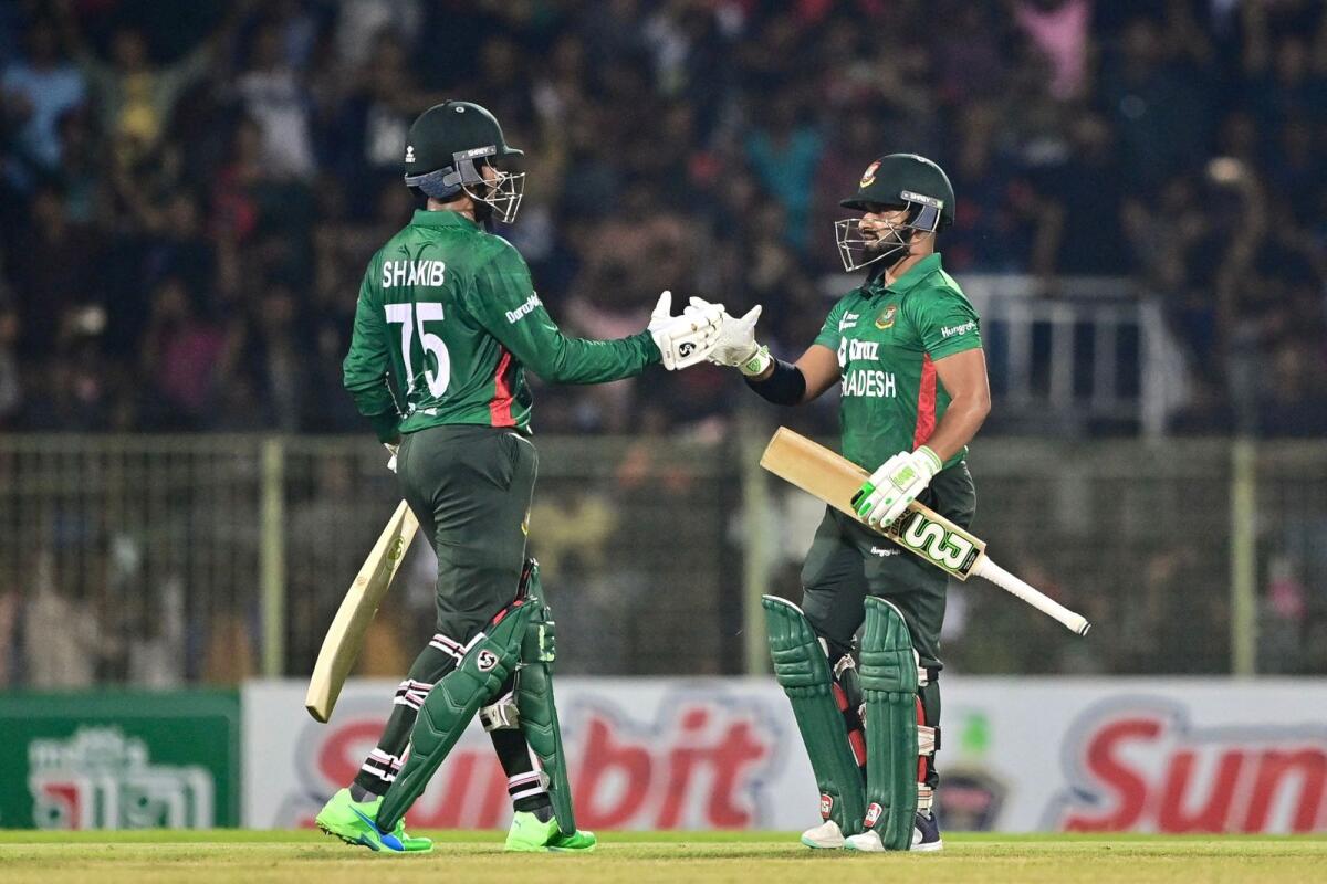 Bangladesh captain Shakib Al Hasan (left) celebrates with his teammate Shamim Hossain after winning the second T20 International at the Sylhet International Cricket Stadium. — AFP