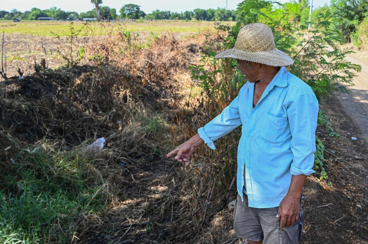 Filipino farmer Eddie Balagtas shows the dried up irrigation canal at a farm in San Antonio, Nueva Ecija.  — AFP