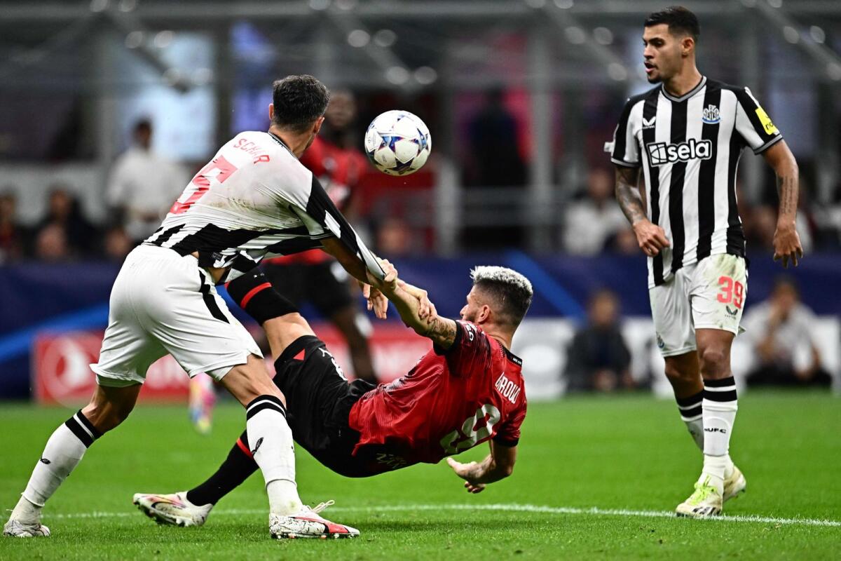 AC Milan's French forward Olivier Giroud (centre) fights for the ball with Newcastle United's Swiss defender (5) Fabian Schar. — AFP