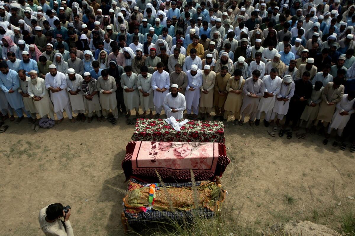 Relatives and mourners attend the funeral prayer of victims who were killed in Sunday's suicide bomber attack in the Bajur district of Khyber Pakhtunkhwa. Photo: AP