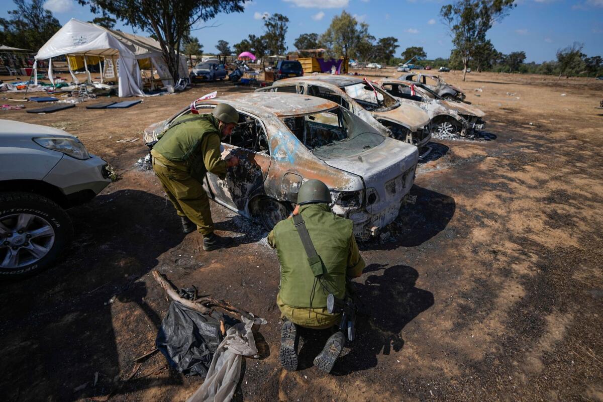 Israeli soldiers inspect the site of a music festival near the border with the Gaza Strip in southern Israel, Friday. Oct. 13, 2023. Photo: AP