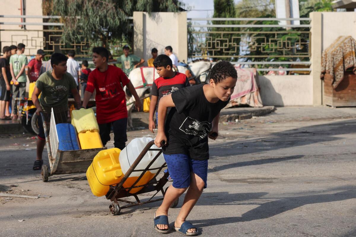 People transport jerricans of water in Rafah in the southern Gaza Strip on October 22, 2023. AFP