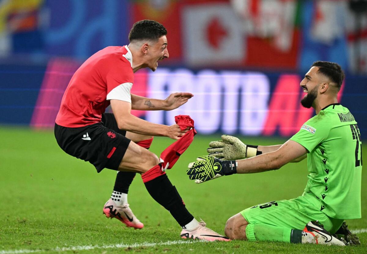Georgia's goalkeeper Giorgi Mamardashvili celebrates with a teammate after winning the match against Portugal. — AFP