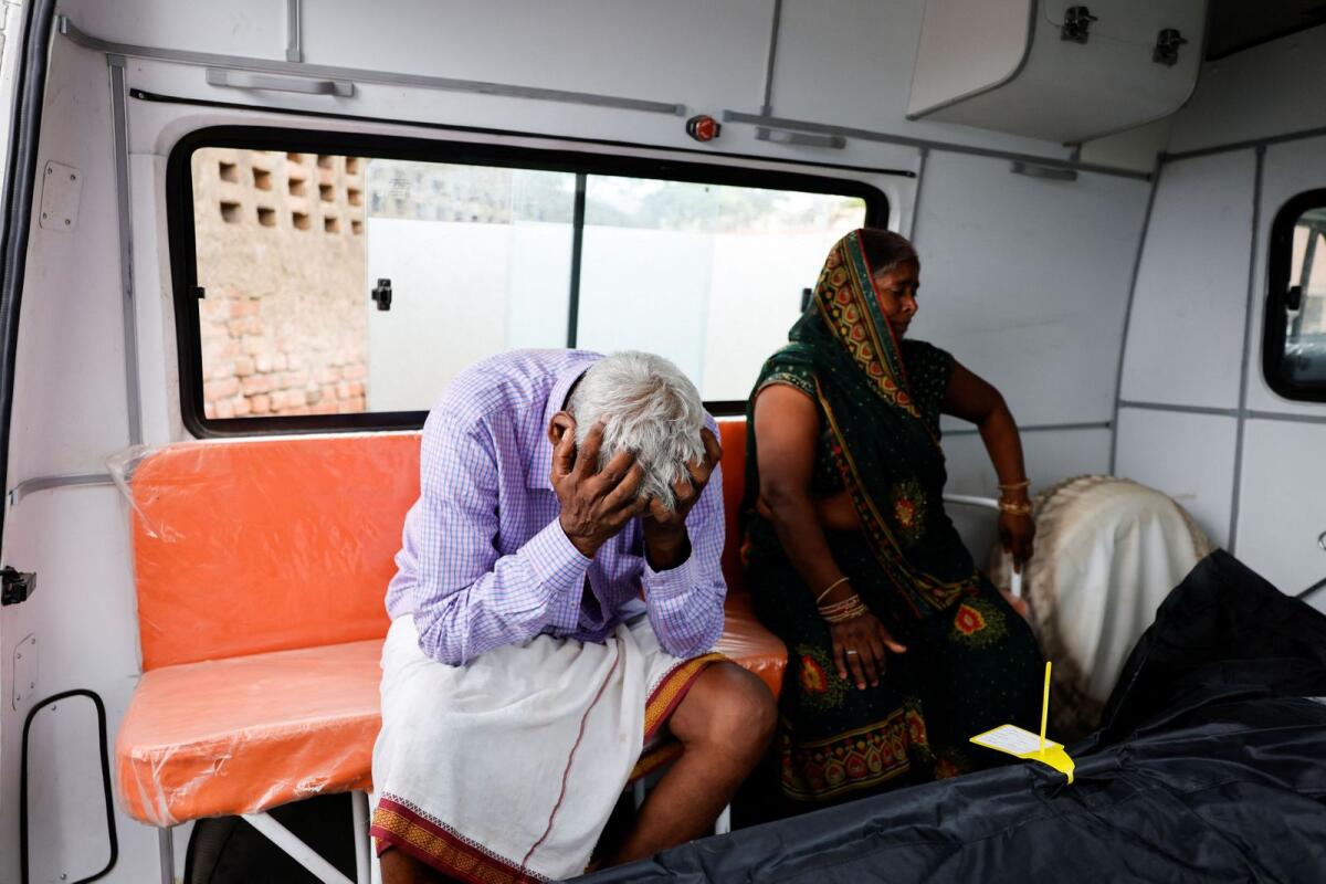 Chedilal and Rajkumari relatives of a stampede victim Ruby, mourn next to her body. Photo: Reuters