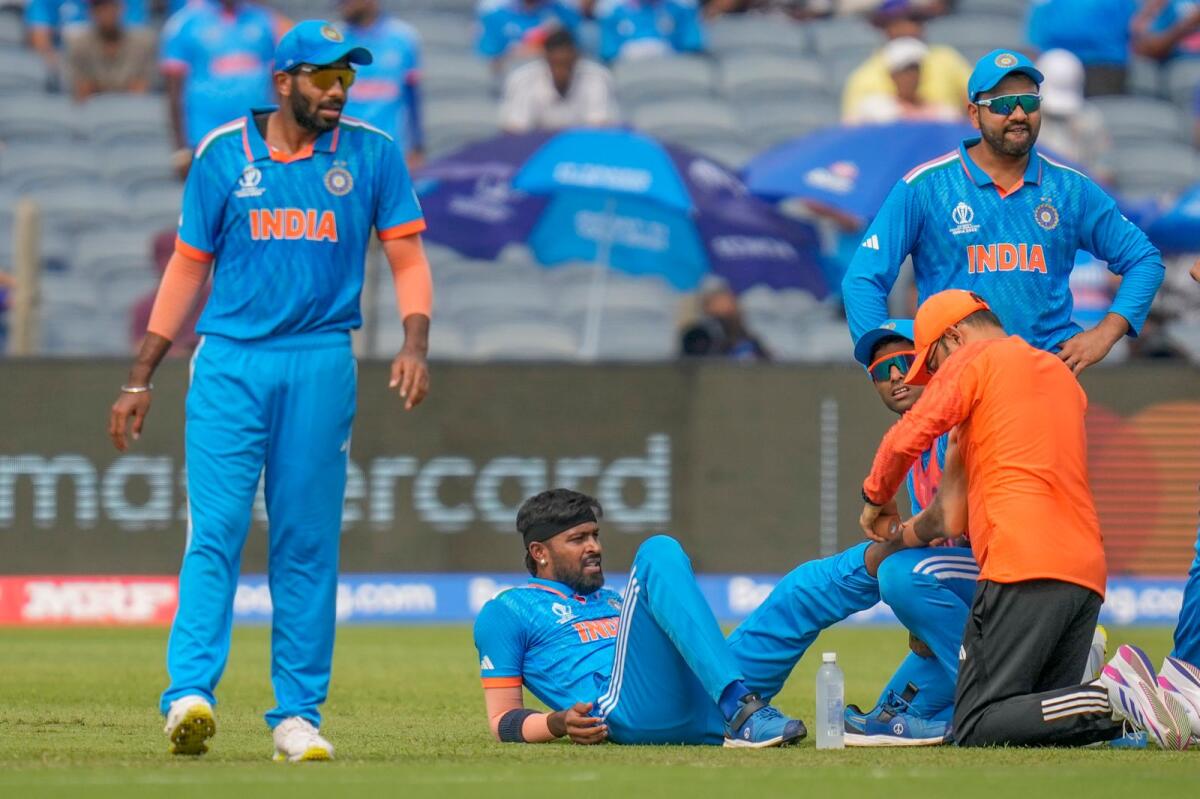 Team physio attends to India's Hardik Pandya, second left, after sustaining an injury during the ICC Men's Cricket World Cup match between India and Bangladesh in Pune, India, Thursday, Oct. 19, 2023. Photo: AP