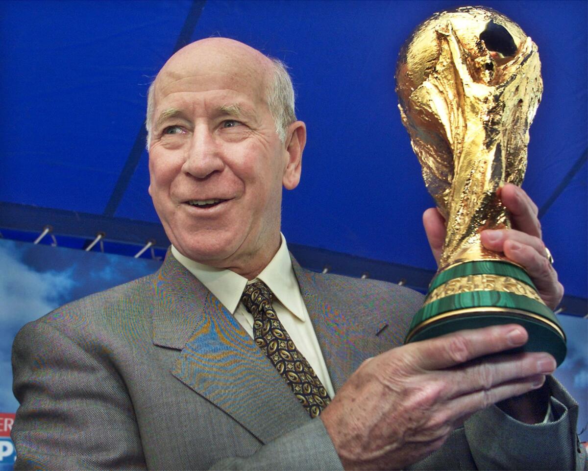FIFA Ambassador and England soccer legend Bobby Charlton holds up the FIFA World Cup trophy. - Reuters File