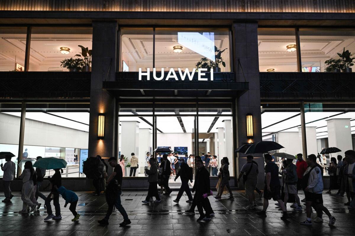 People walk past a Huawei shop in the Huangpu district in Shanghai on June 5, 2024. — AFP