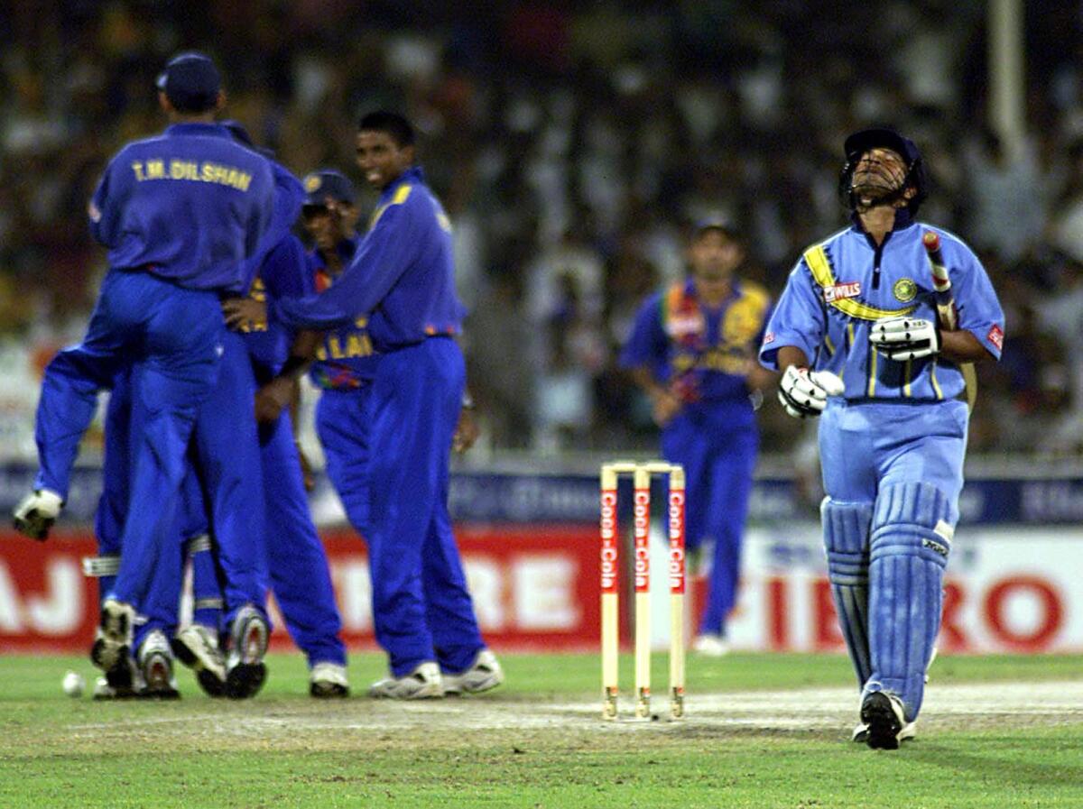 India's Sachin Tendulkar (right) walks off the pitch after being caught and bowled by Chaminda Vaas in the tri-nation Coca-Cola Champions Trophy final in Sharjah in October, 2000. — AFP file