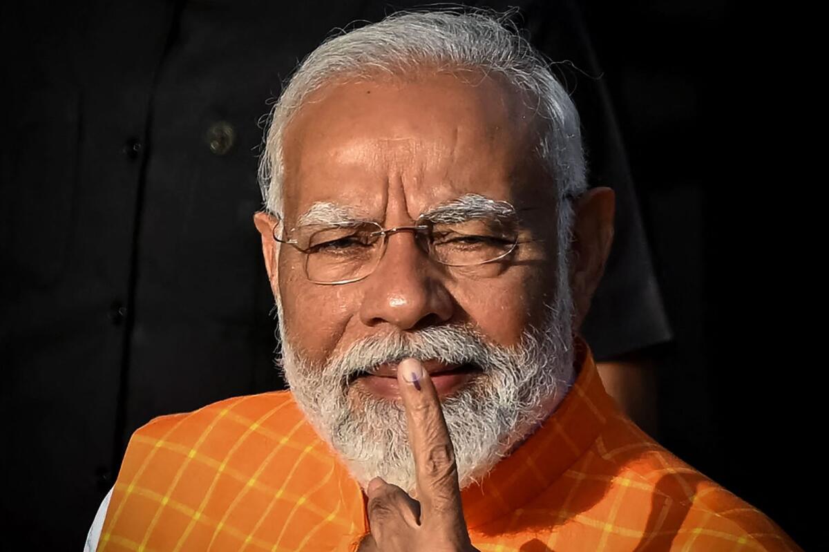 India's Prime Minister Narendra Modi, leader of the ruling Bharatiya Janata Party, displays his ink marked finger after casting his ballot at a polling booth at Ranip, Ahmedabad, on Tuesday. — AFP