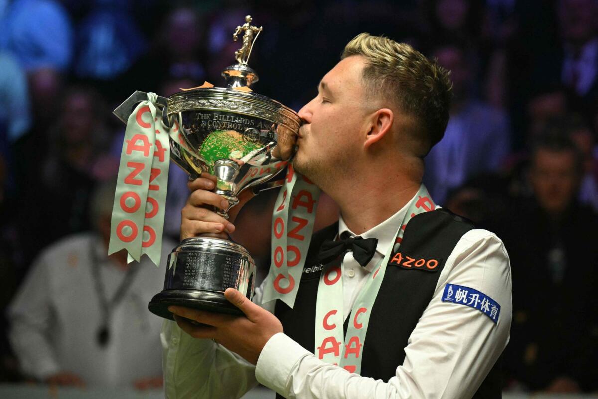 England's Kyren Wilson kisses the trophy after beatingWales' Jak Jones to win the World Championship Snooker final at The Crucible in Sheffield, northern England on May 6. - AFP