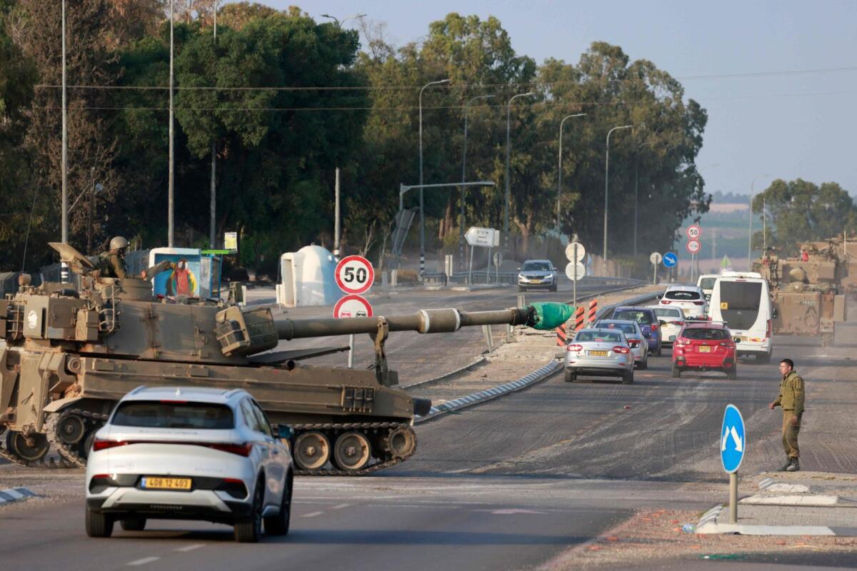 Israeli forces cross a main road in their self-propelled howitzer as additional troops are deployed near the southern city of Sderot on October 8, 2023. Photo: AFP