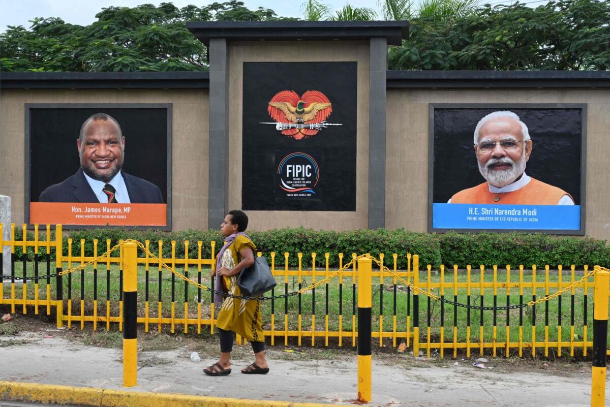 A woman walks past pictures of Papua New Guinea’s Prime Minister James Marape, left, and India’s Prime Minister Narendra Modi ahead of the India-Pacific Leaders Meeting in Port Moresby on Wednesday. Photo: AFP