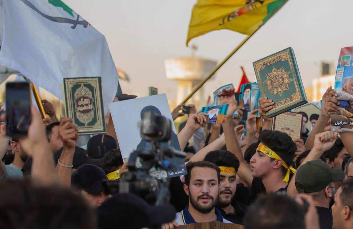 Iraqis raise copies of the Quran during a protest in Tahrir Square, Baghdad. Photo: AP