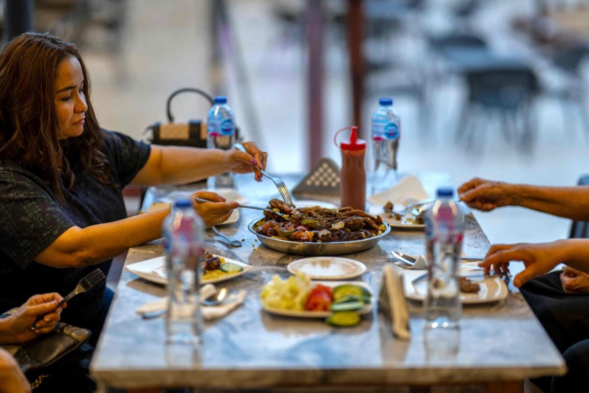 Clients are served traditional Sudanese food at a restaurant run by a businesswoman who relocated to the Egyptian capital Cairo after fleeing the ongoing war in Sudan on May 21, 2024. — AFP