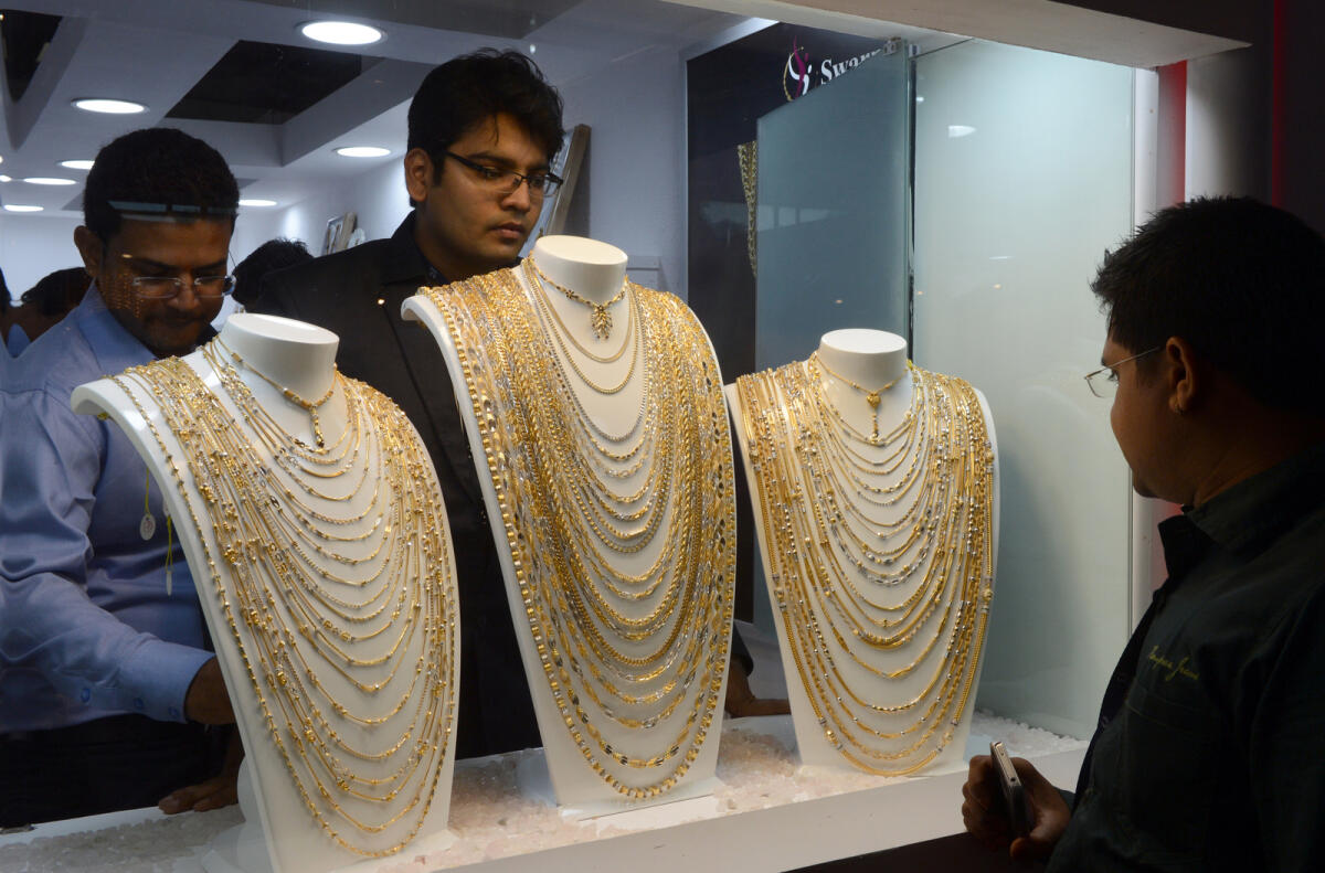 Visitors look at gold ornaments displayed in a jewellery shop. Photo: AFP
