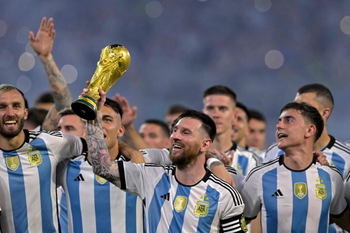 Argentina's Lionel Messi (centre) raises a replica of the World Cup trophy next to his teammates during a felicitation ceremony for the World Cup-winning players in Santiago del Estero, Argentina, on March 28. — AFP