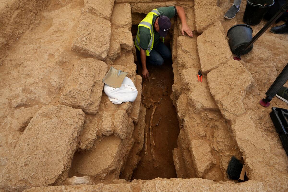 A Palestinian archaeologist removes the sand from a skeleton in a grave at the Roman cemetery in Jebaliya northern Gaza Strip, Saturday, Sept. 23, 2023. – AP